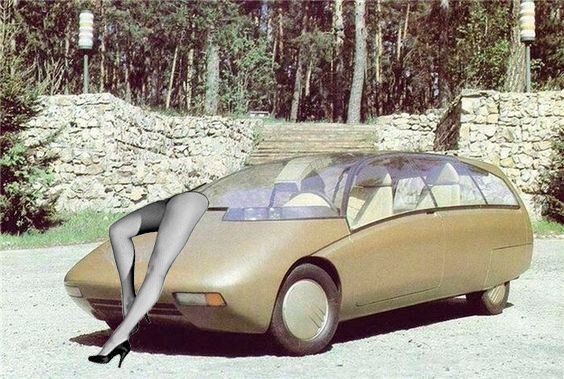 Futuristic brown car with a woman's leg in high heel, posed against a stone wall and trees.