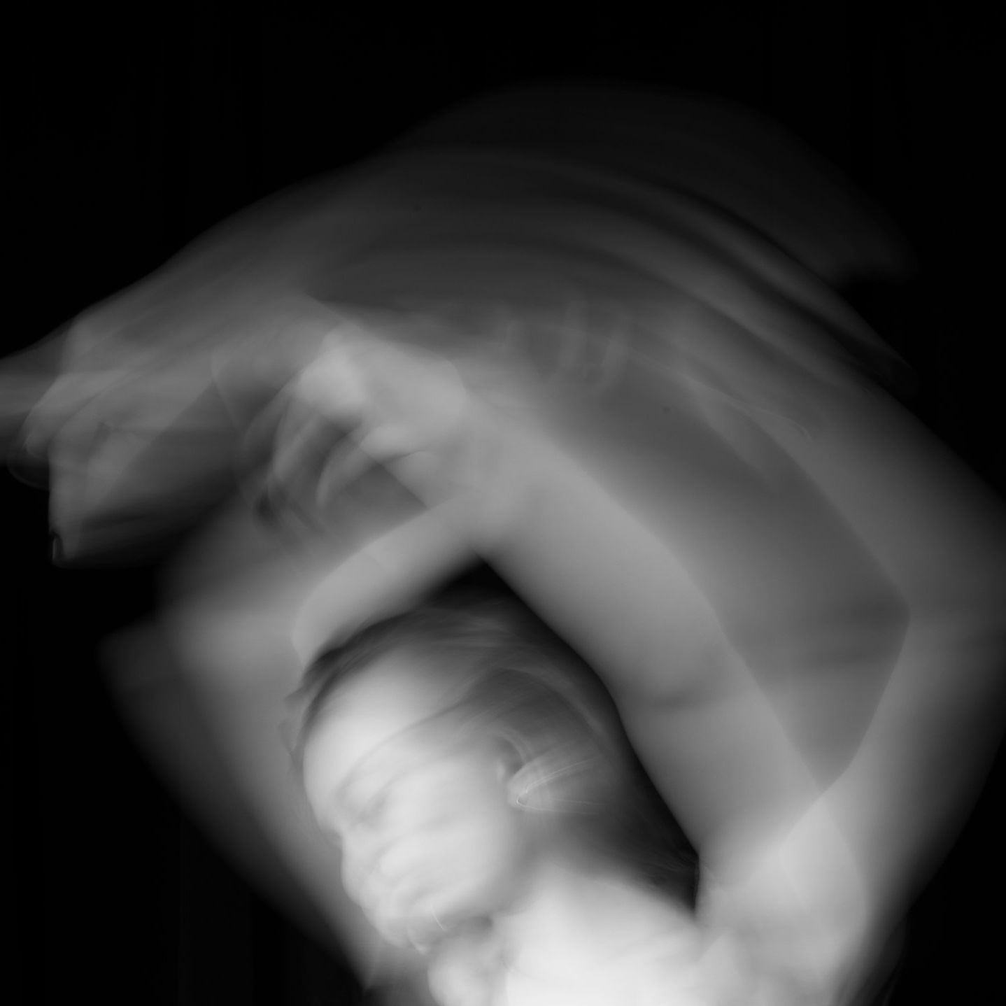 A blurry black and white photo of a man moving in the dark.