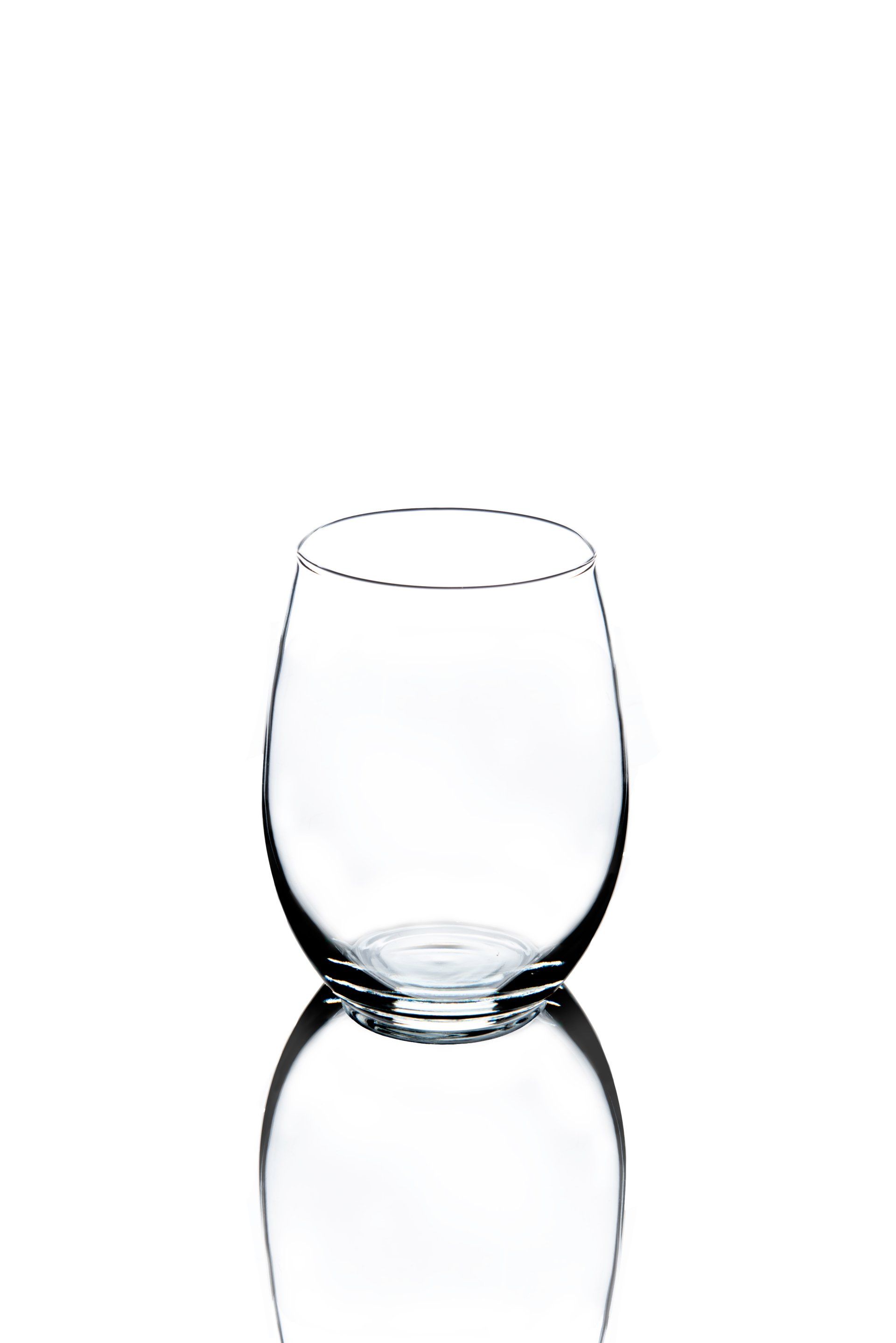 Empty, stemless wine glass, reflecting on a white surface.