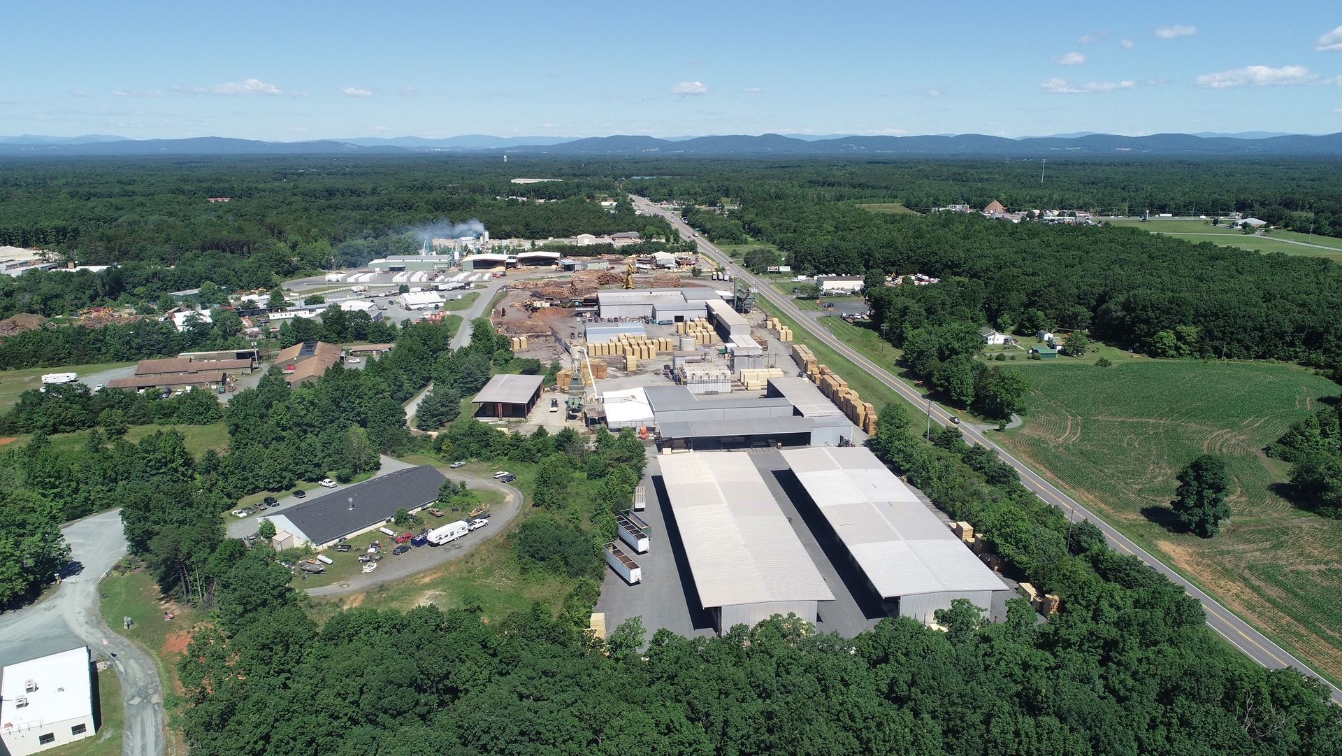 An aerial view of a large industrial area surrounded by trees and buildings.