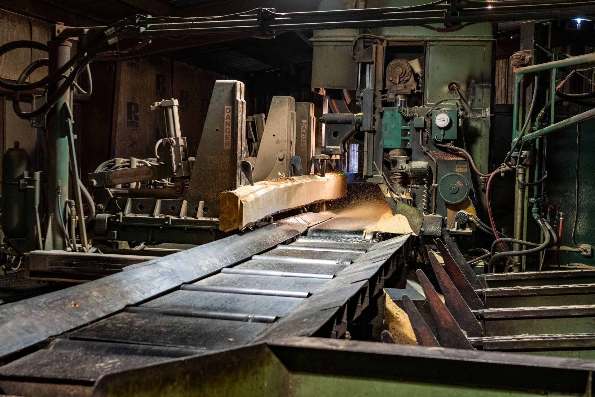 A machine is cutting a log in a factory.