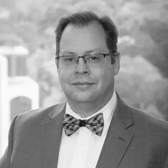 A man in a suit and bow tie is wearing glasses and a bow tie.