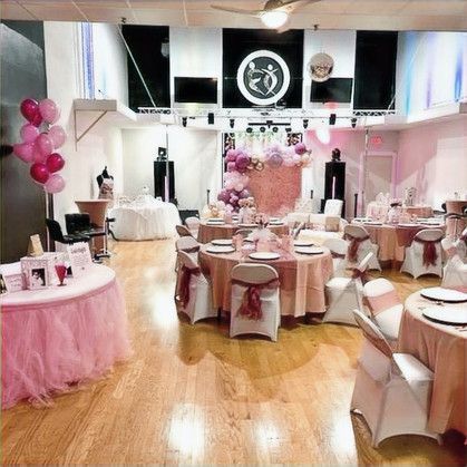 A large room with tables and chairs set up for a party