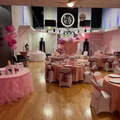 A large room with tables and chairs set up for a party.