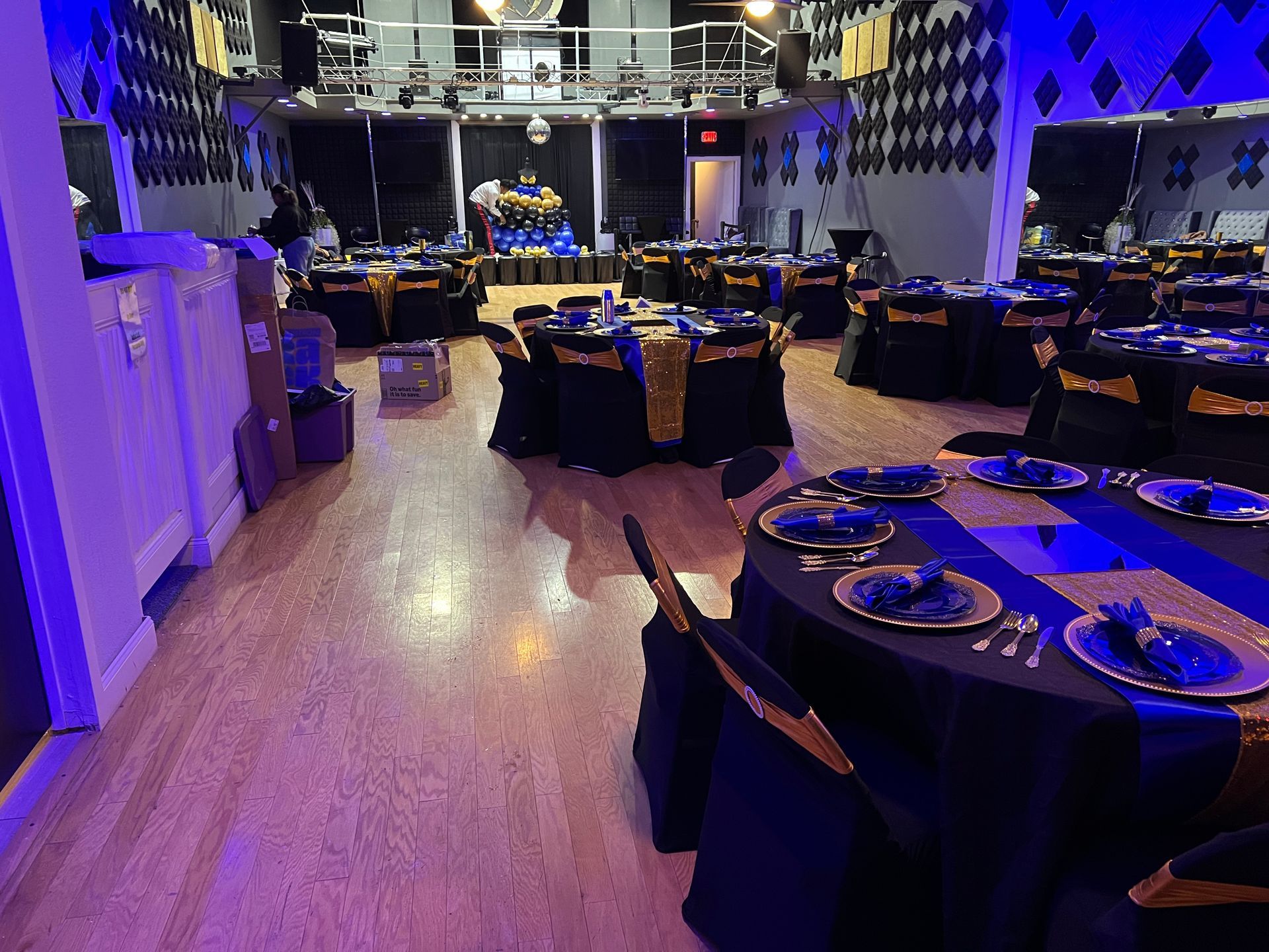A large room with tables and chairs set up for a party.