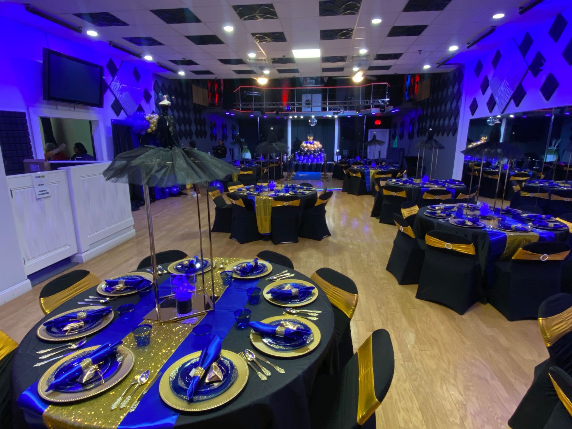 A table set for a wedding reception with plates , glasses , and napkins on it.