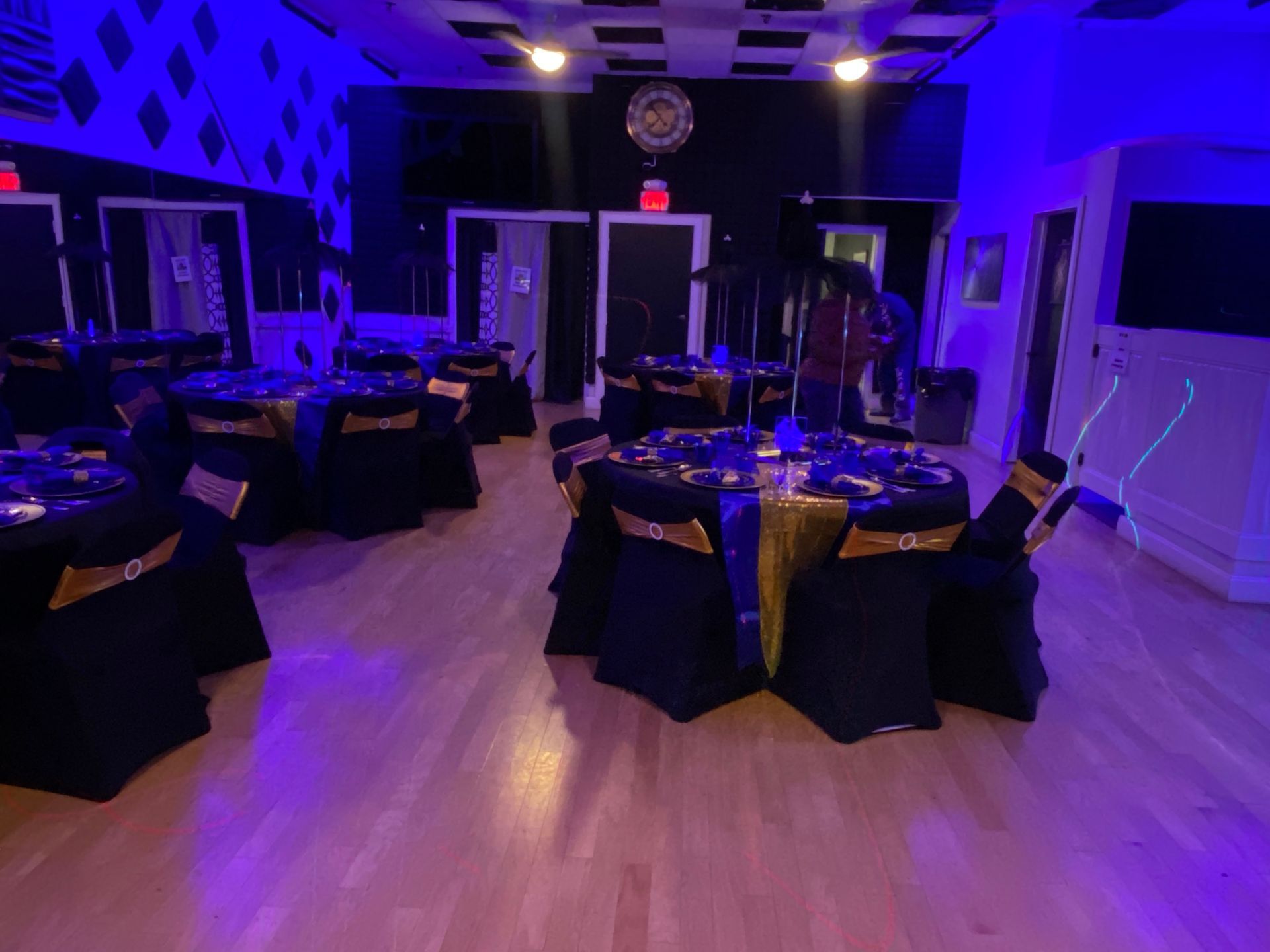 A large room with tables and chairs set up for a party.
