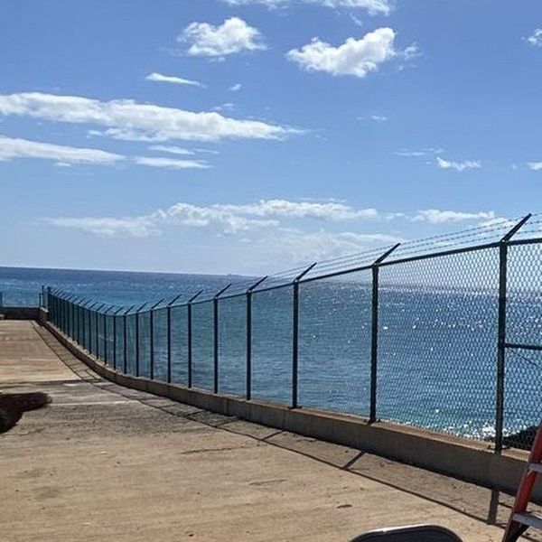 A fence with a view of the ocean behind it