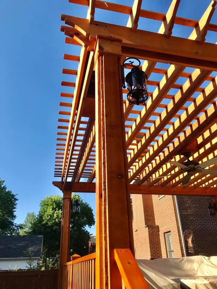 A wooden pergola with a lantern hanging from it