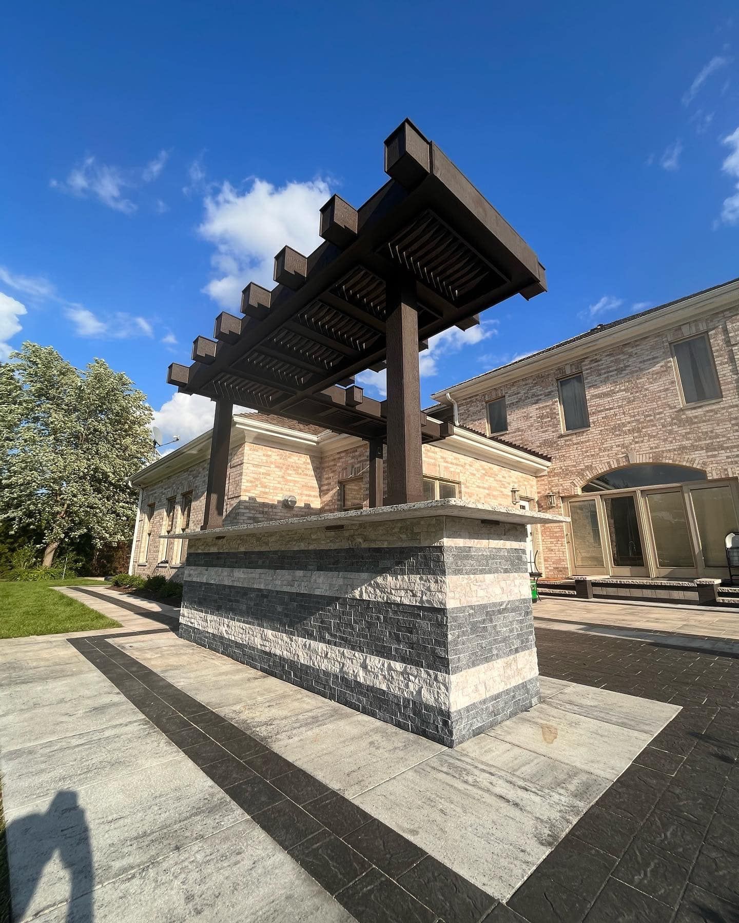 A brick building with a pergola in front of it