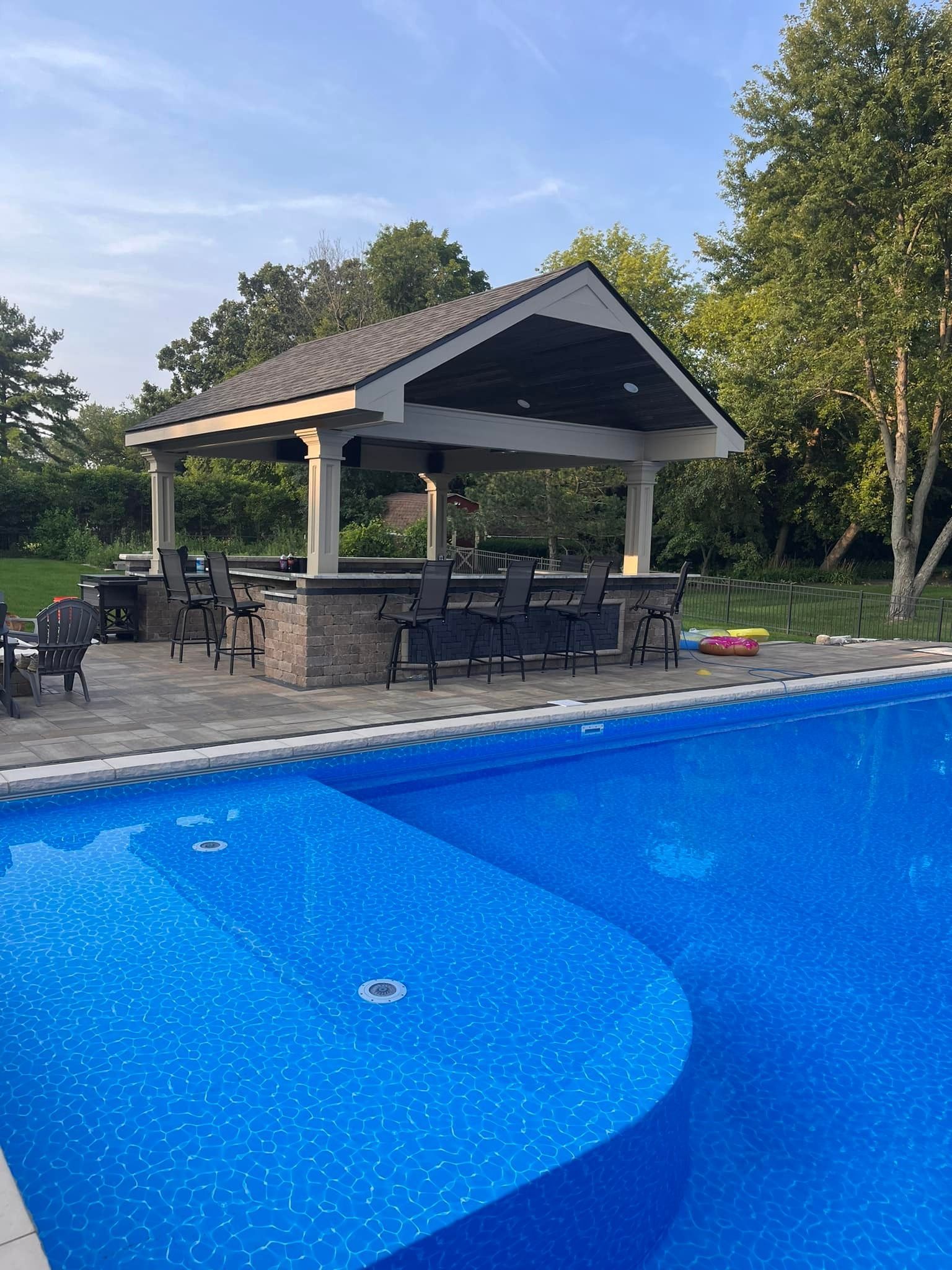 A large swimming pool with a gazebo in the middle of it.