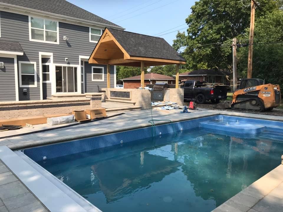 A large swimming pool is being built in front of a house.