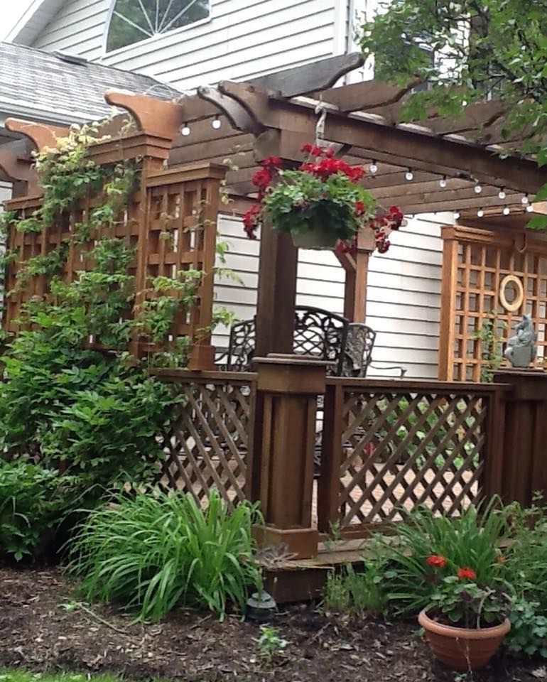 A wooden pergola with flowers hanging from it