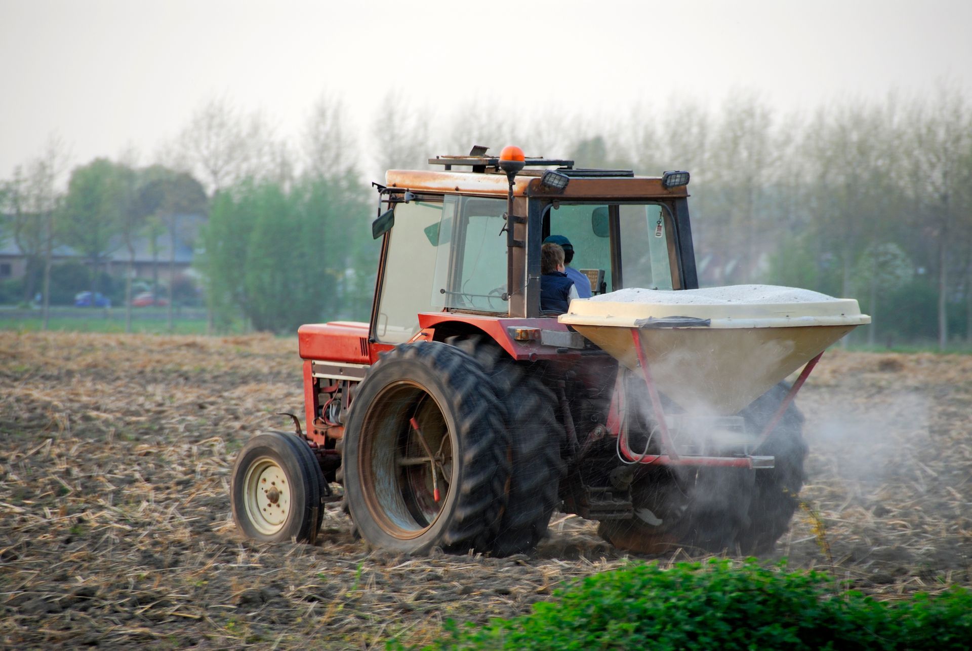A tractor is spraying fertilizer on a field.