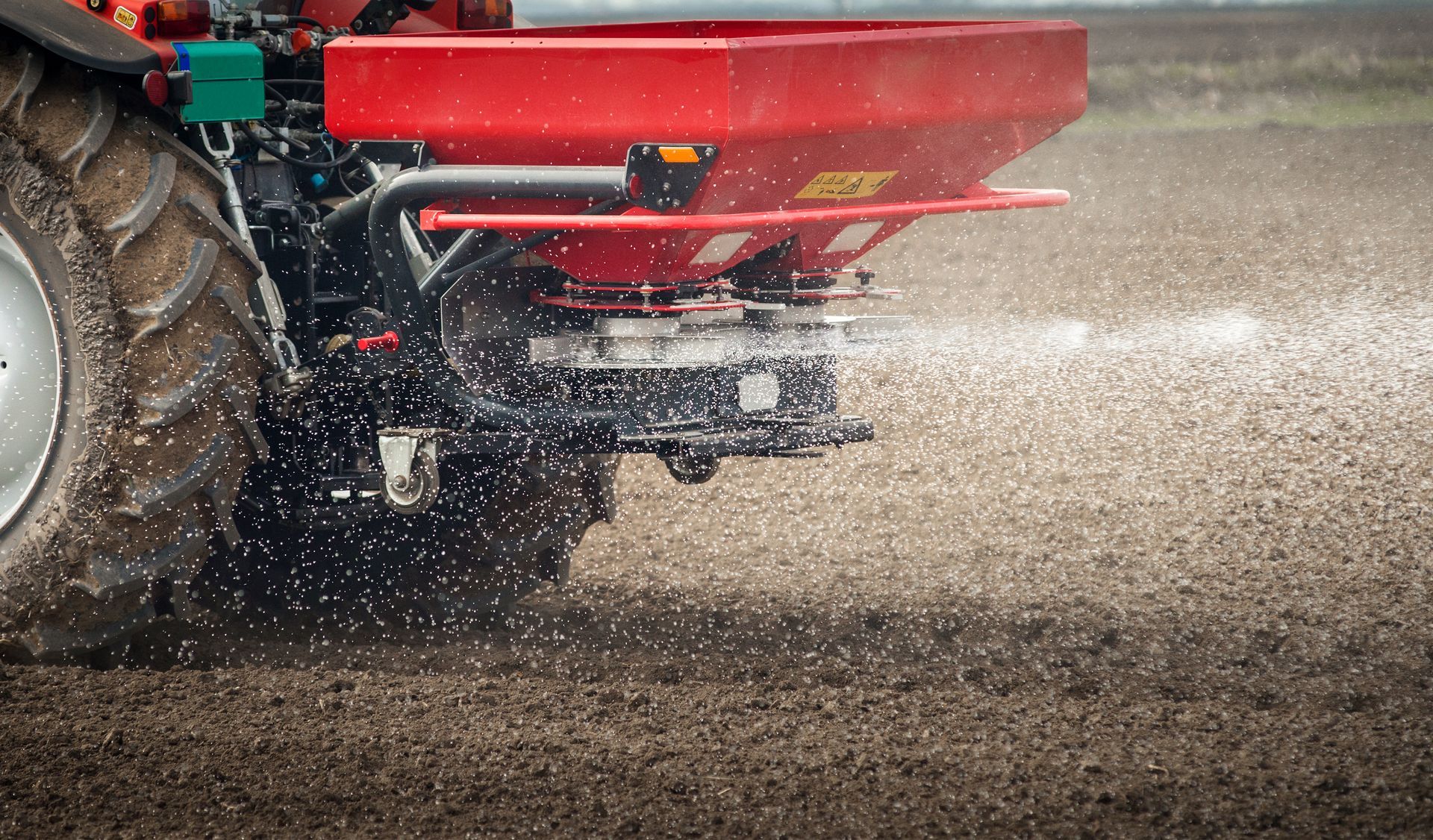 A tractor is spraying fertilizer on a field.