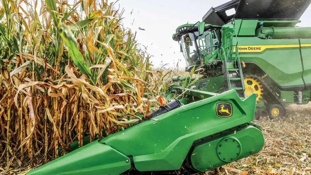 A tractor is spraying a field of plants with a sprayer.