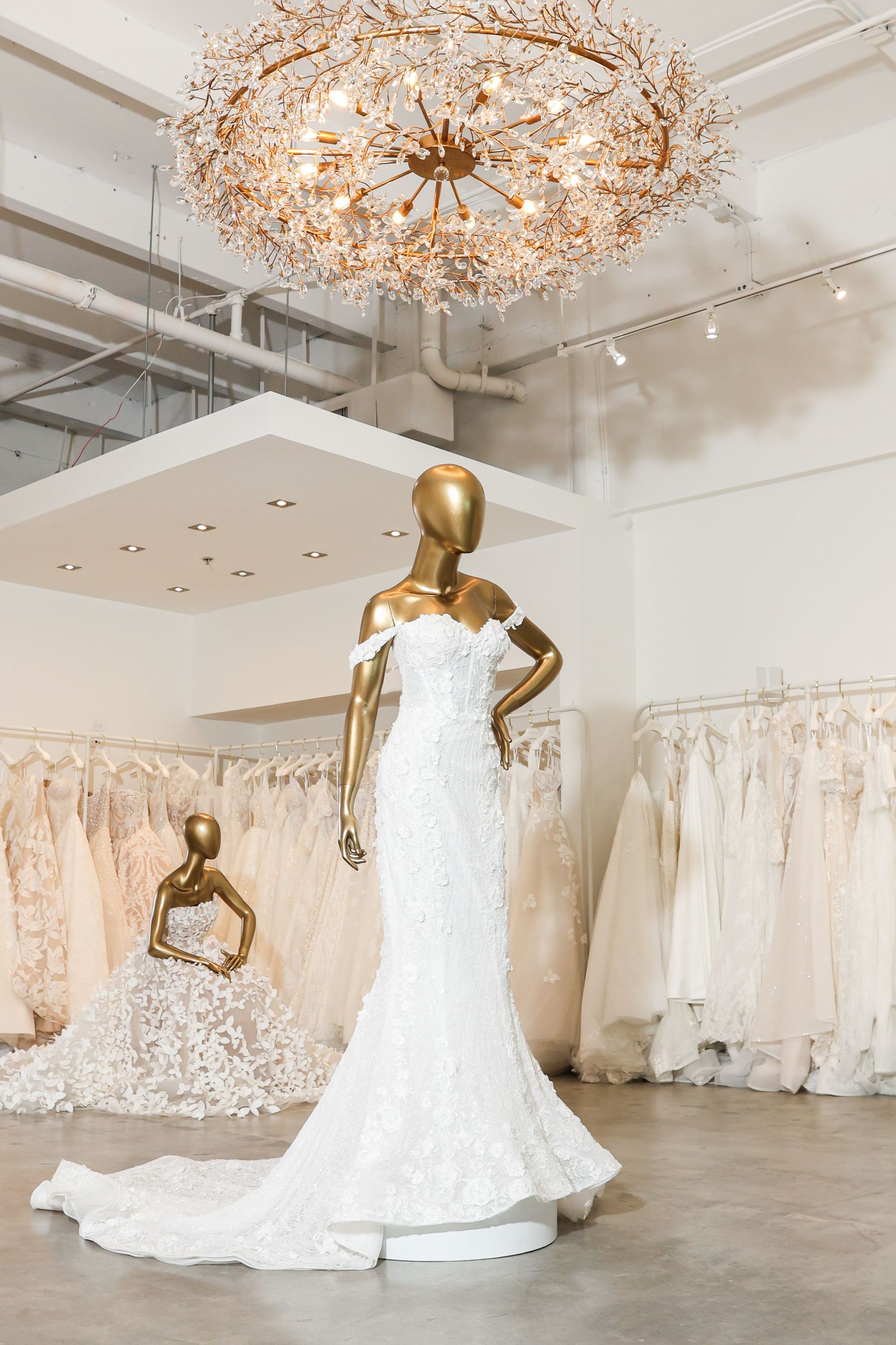 Inside the showroom of House Of Luxe Bridal Atelier in Miami with a gold mannequin in a wedding dress. 