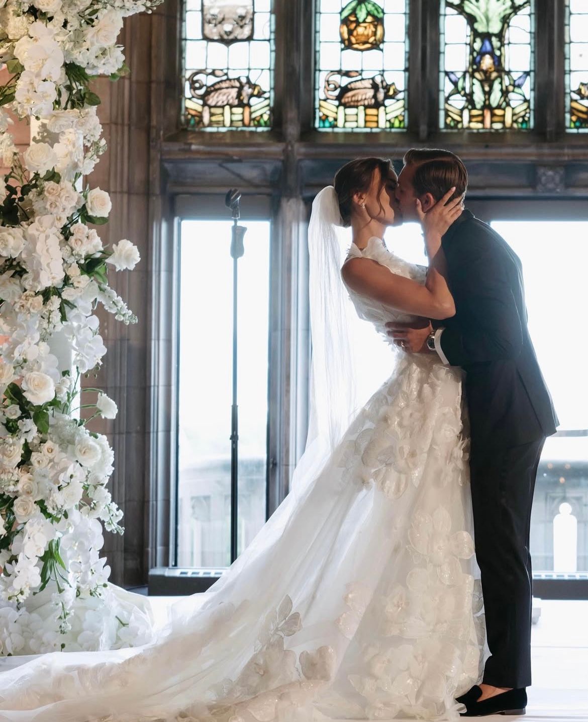 A bride is holding a bouquet of white roses