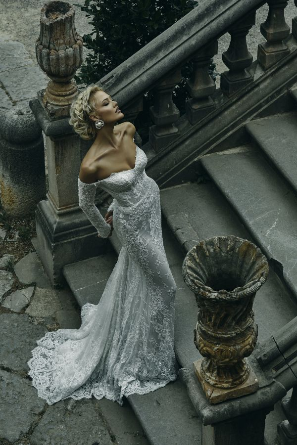 A woman in a wedding dress is standing on a set of stairs.
