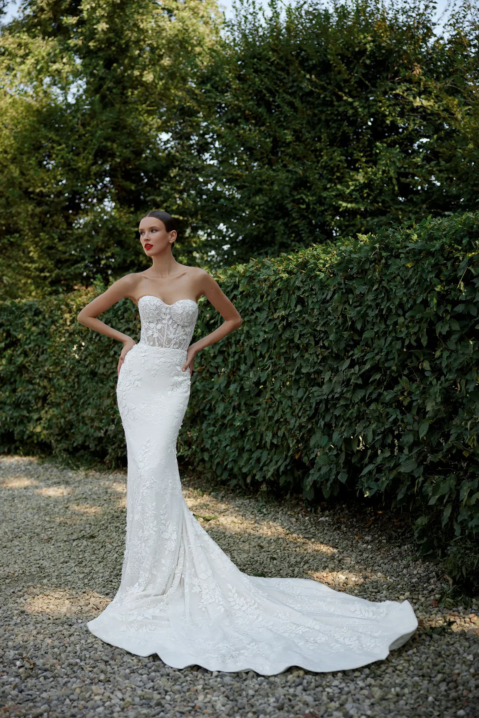 A black and white photo of a woman in a wedding dress surrounded by flowers.