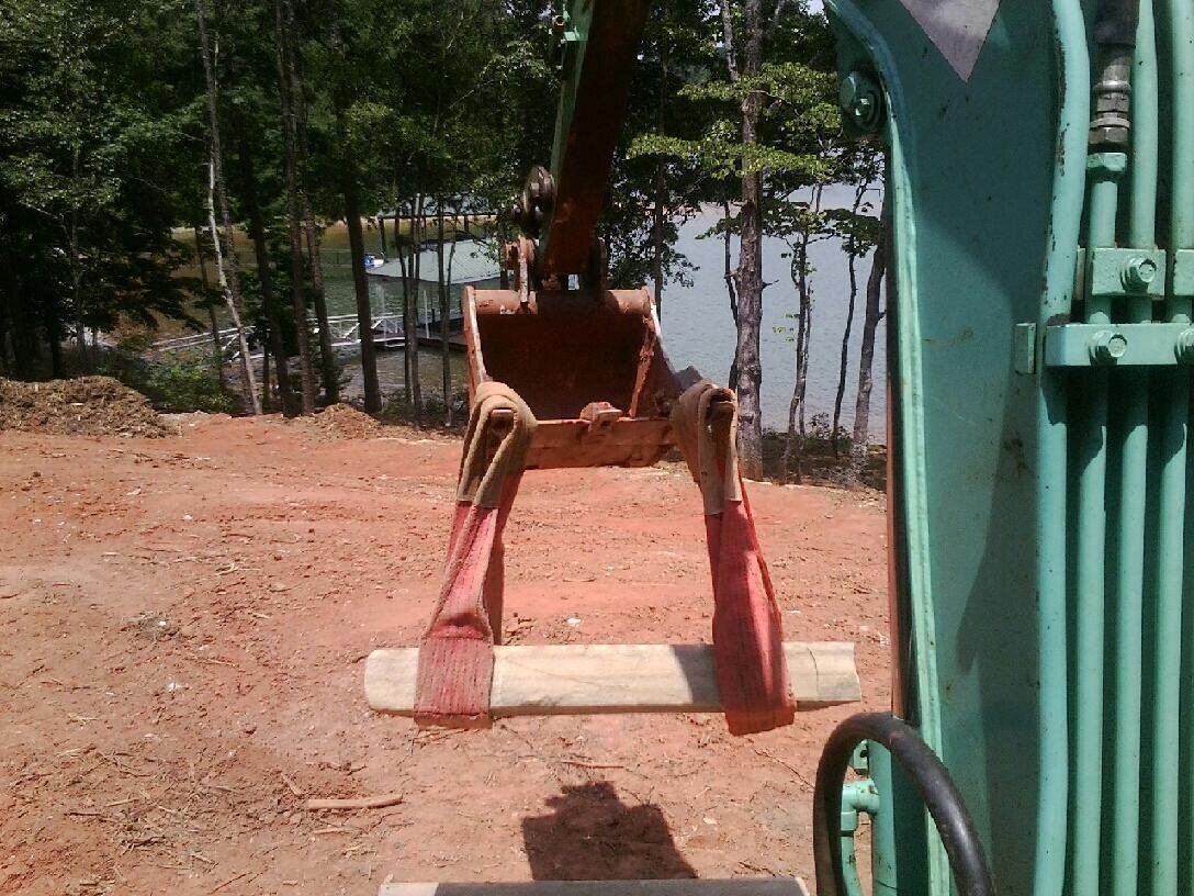 Excavator Lifting a Wood — Seneca, SC — Sheriff Landscaping