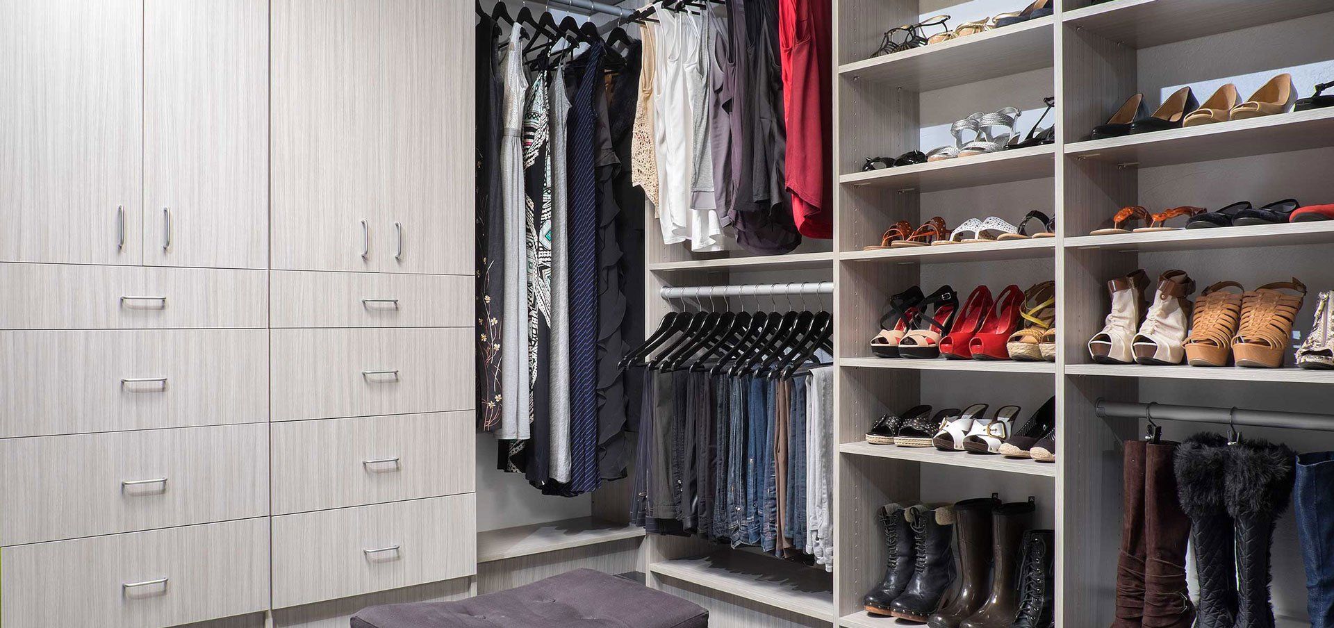 A walk in closet filled with lots of clothes and shoes.