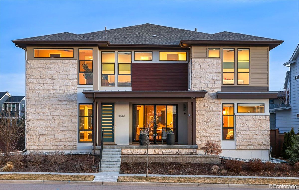 A house with a lot of windows is lit up at night