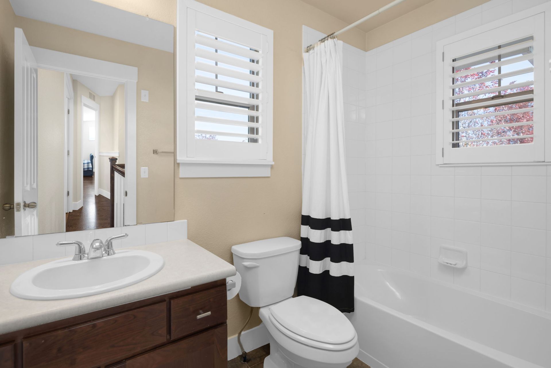A living room with a couch , fireplace , television and ceiling fan.