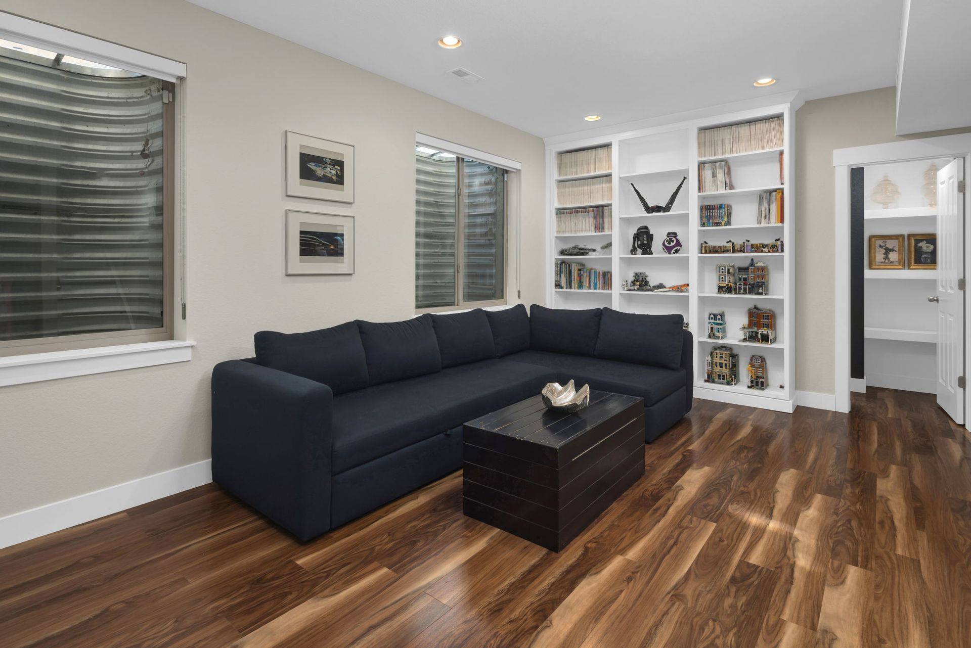 A kitchen with a large island and stools and a clock on the wall.