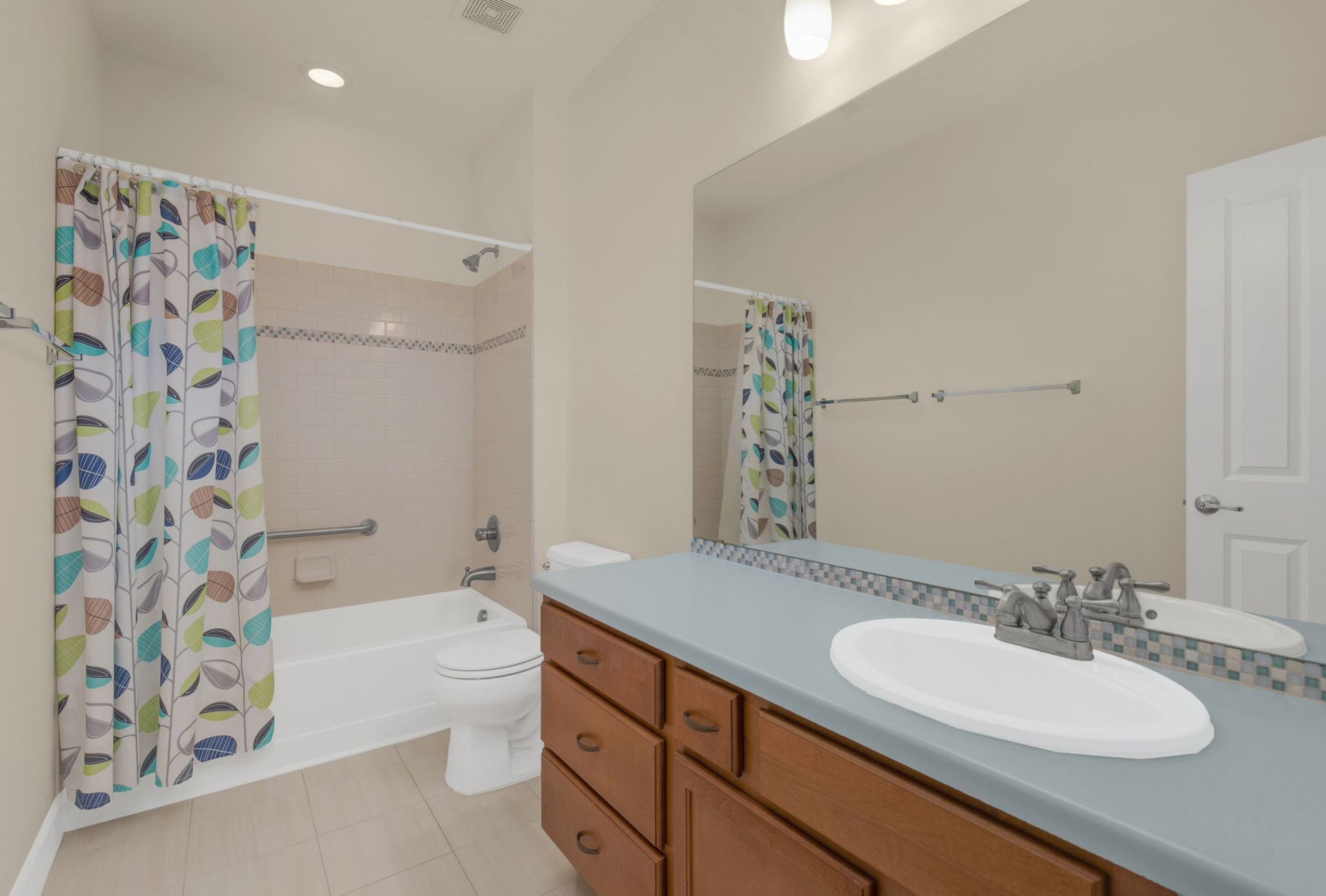 An empty kitchen with hardwood floors and stainless steel appliances