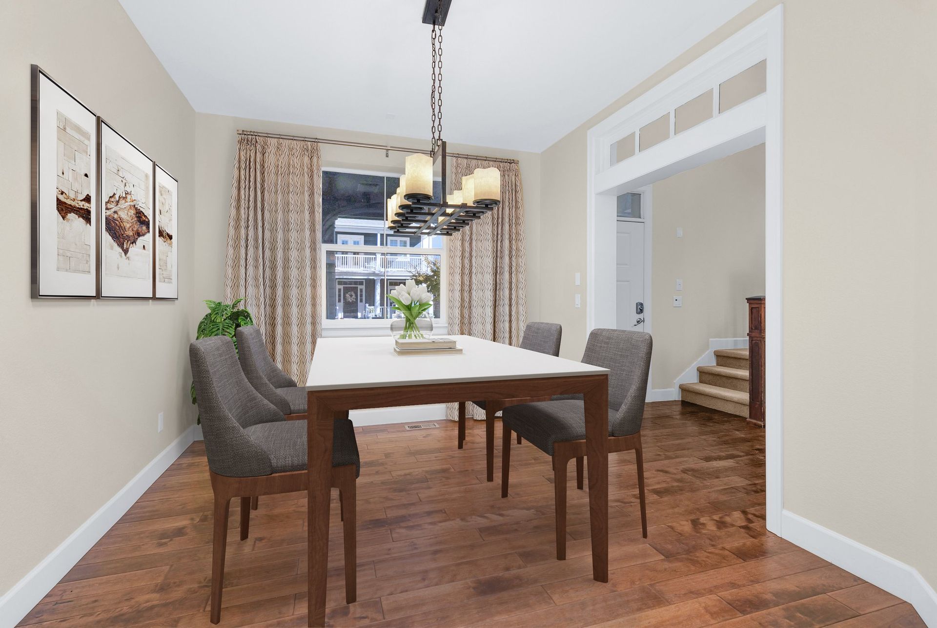 An empty kitchen with hardwood floors and stainless steel appliances