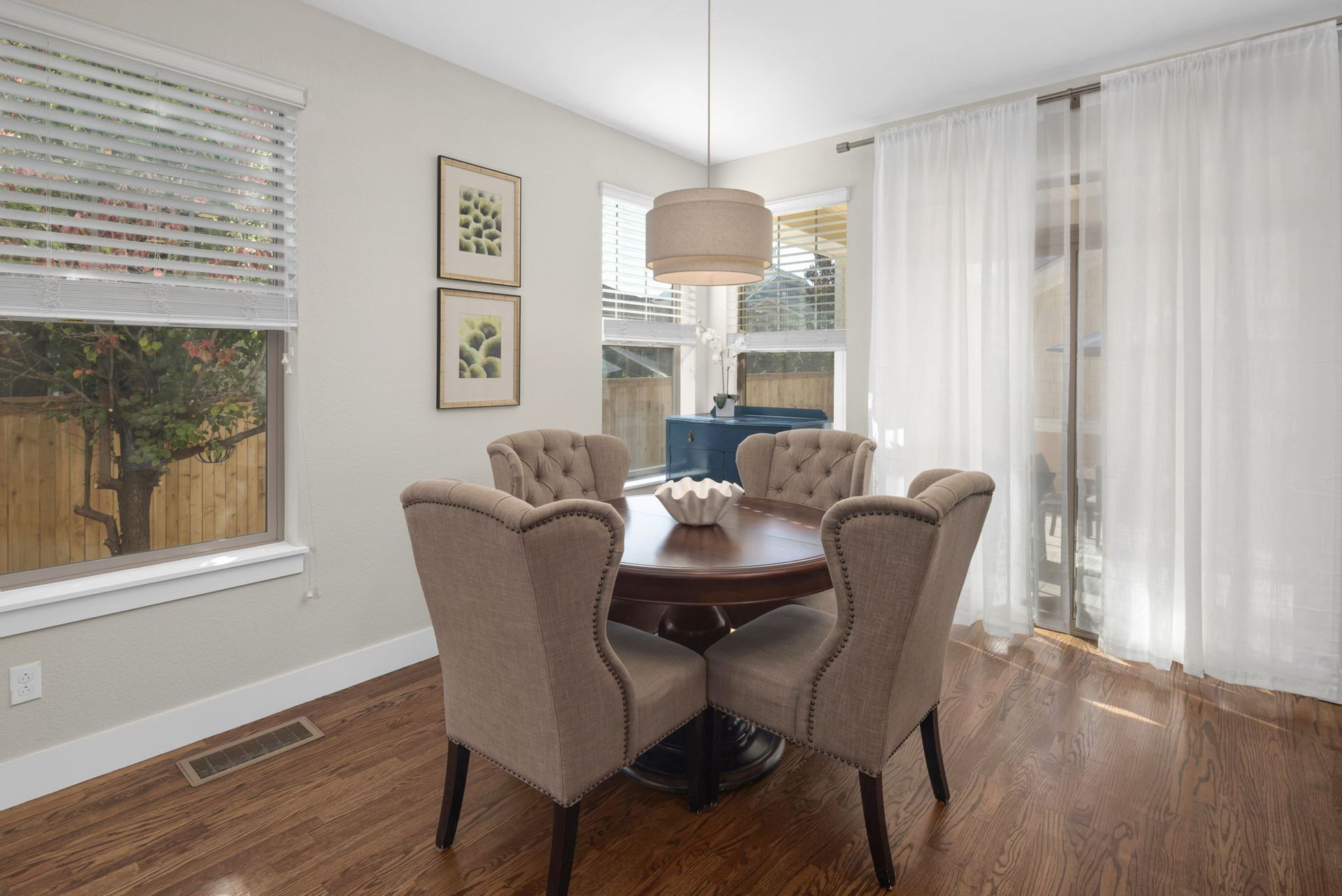 A bedroom with a bed , lamp , table and window.