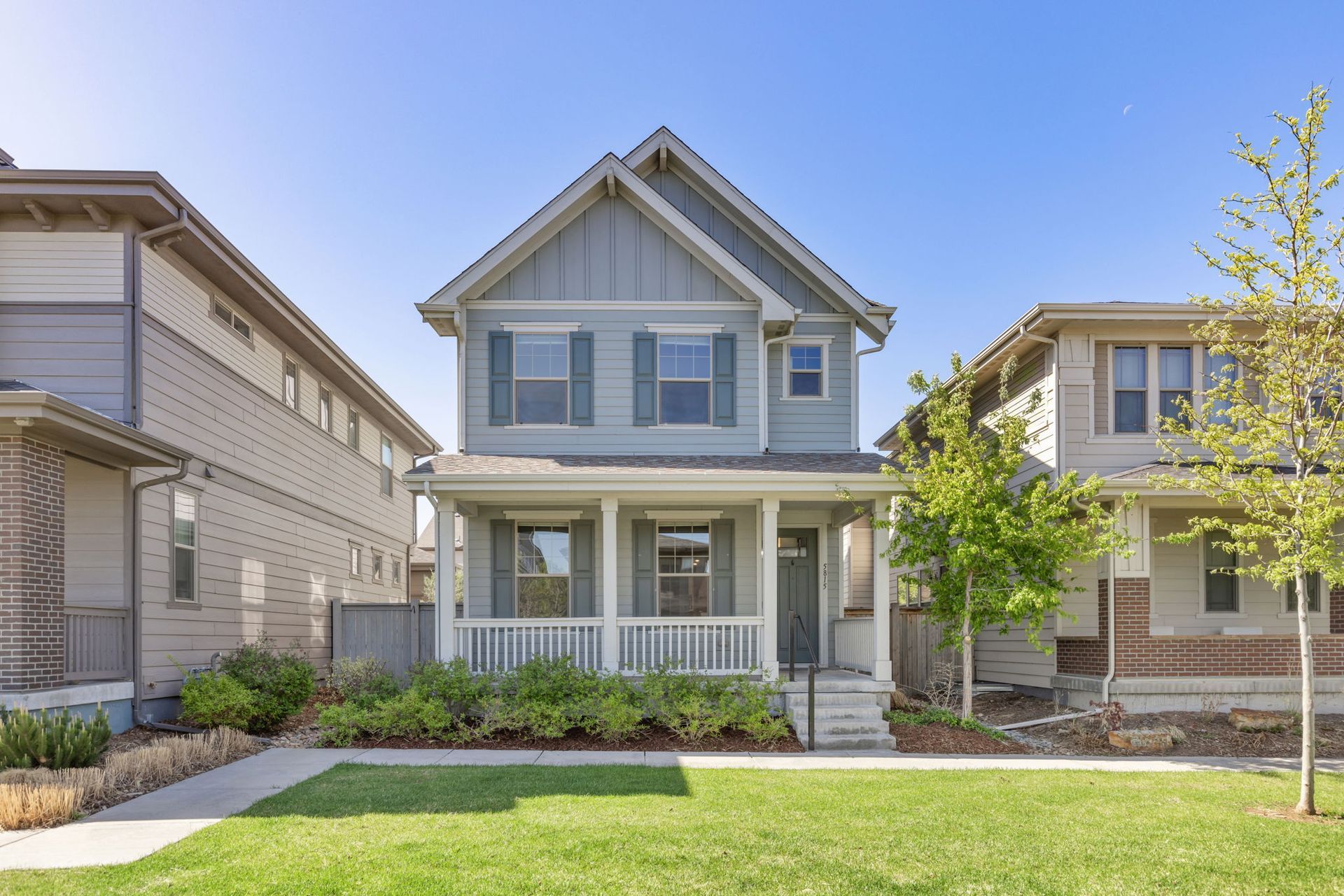 A red house with a porch in a residential area