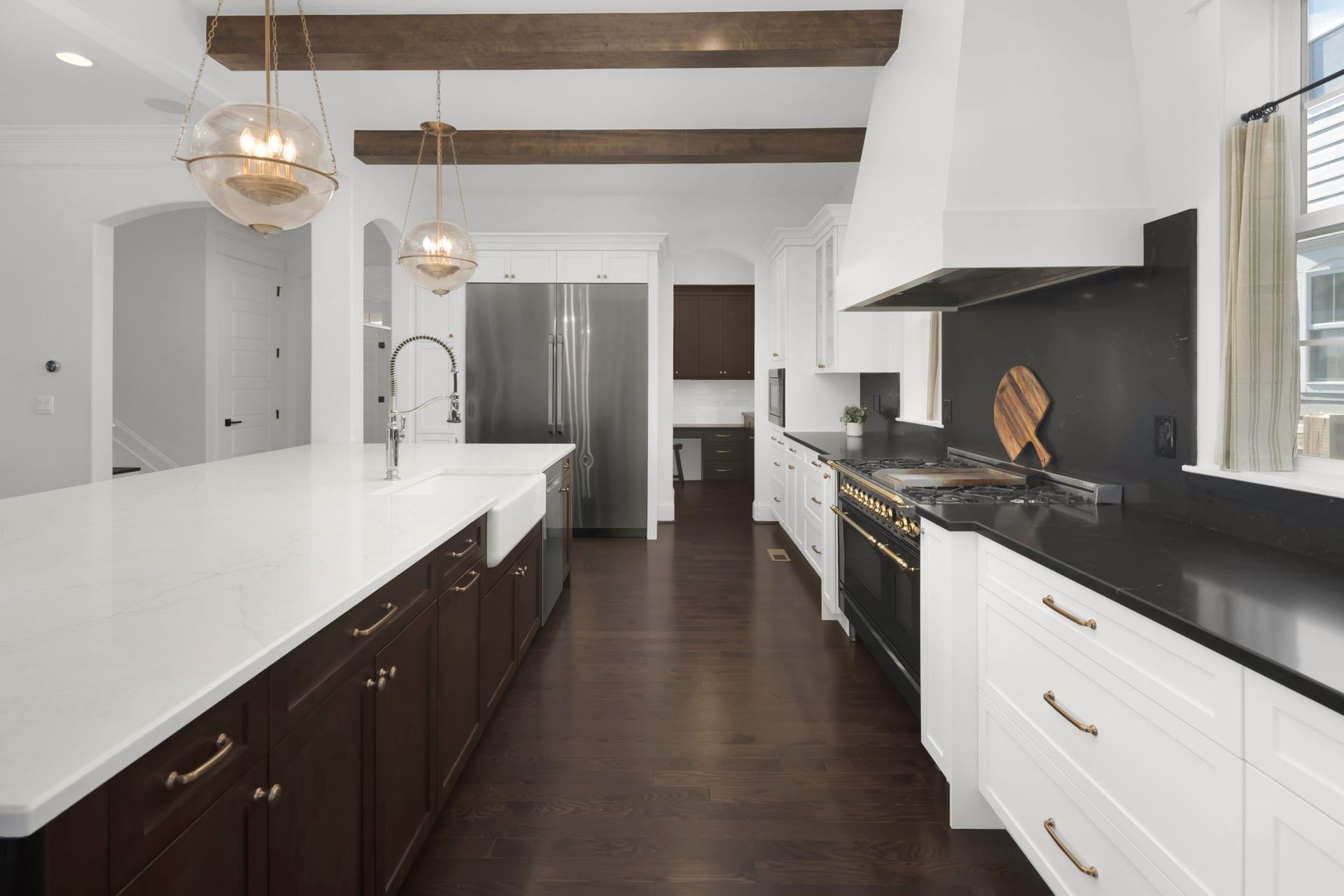 A kitchen with white cabinets , black counter tops , and stainless steel appliances.