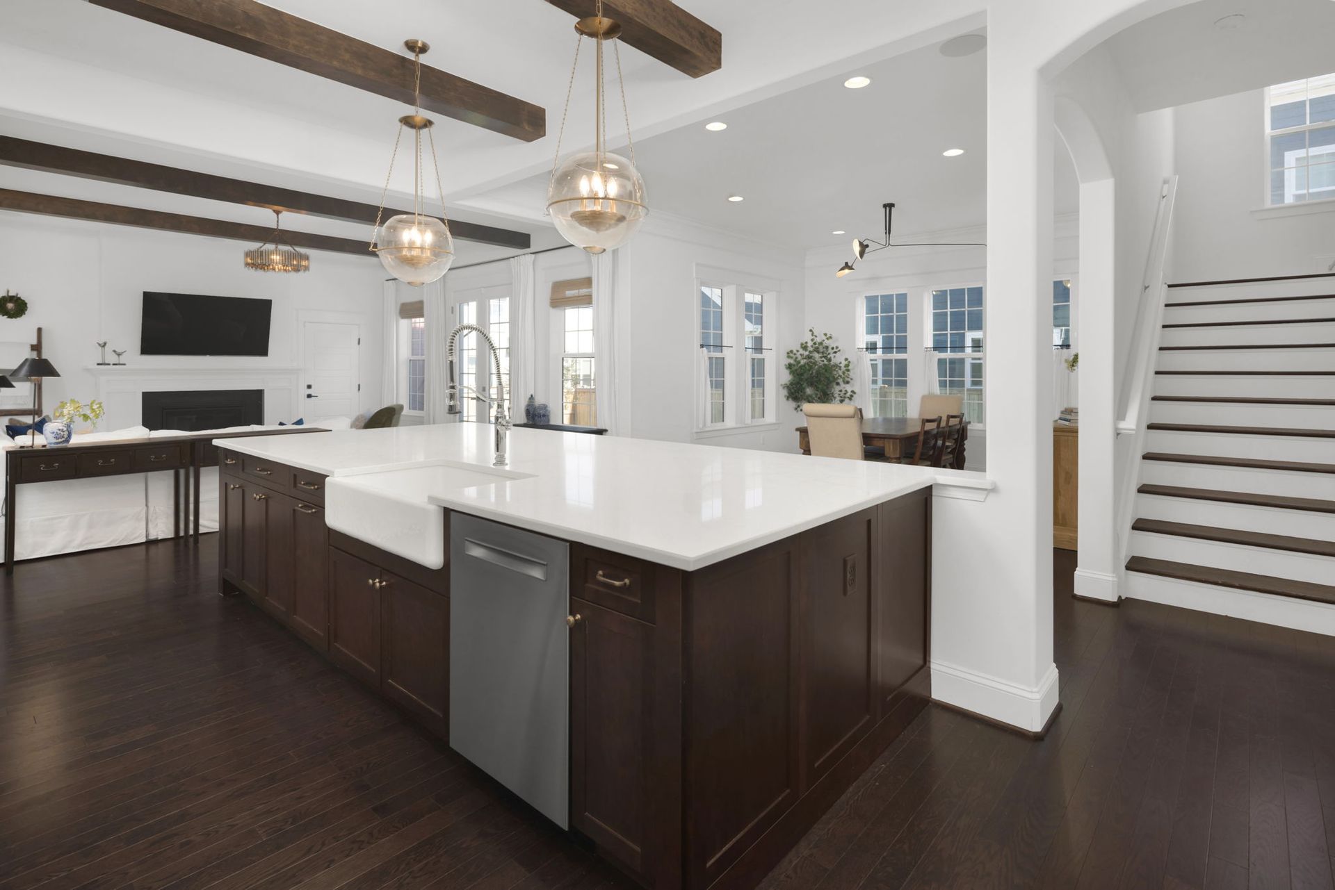 A kitchen in a house with a large island and stairs
