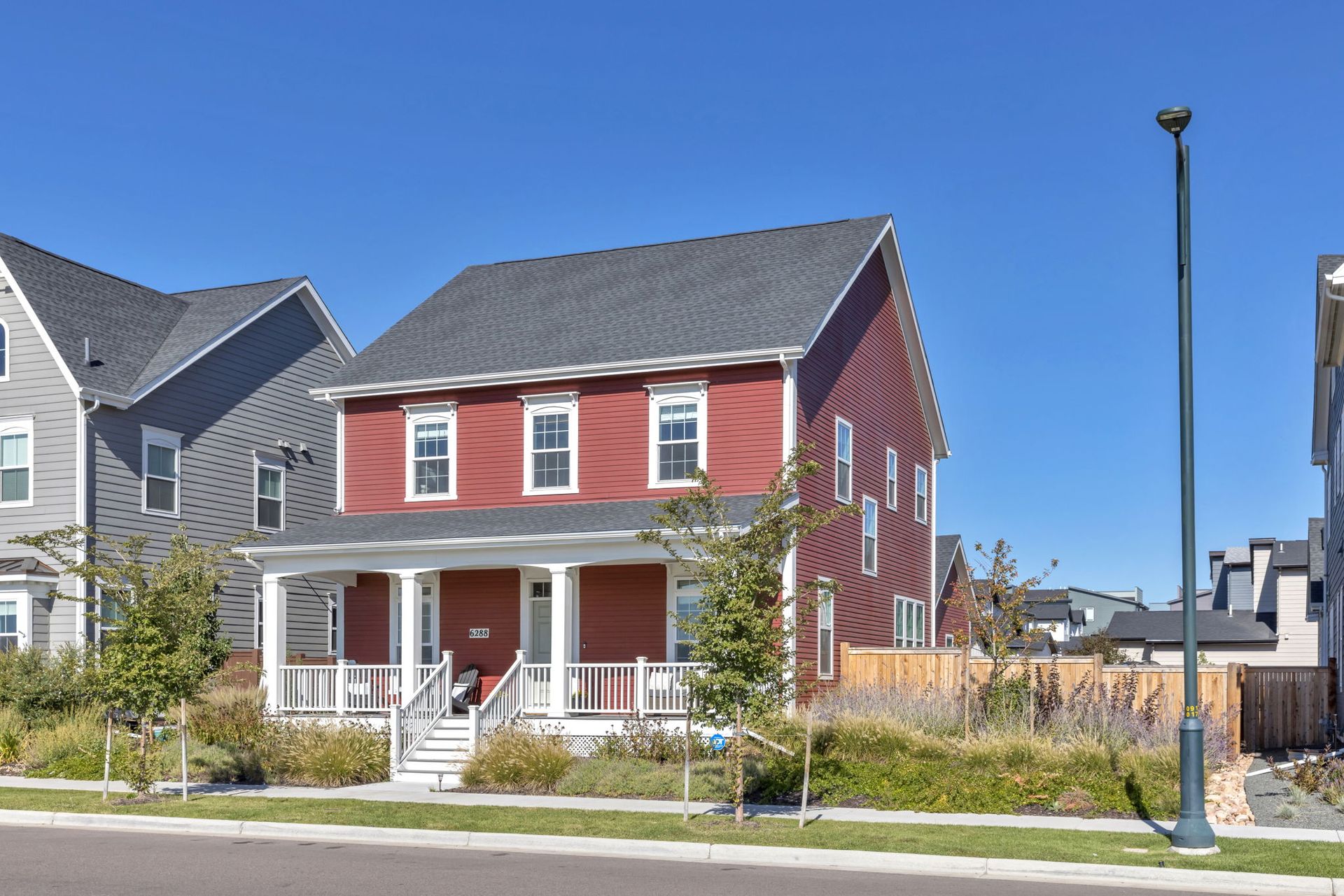 A red house with a porch in a residential area