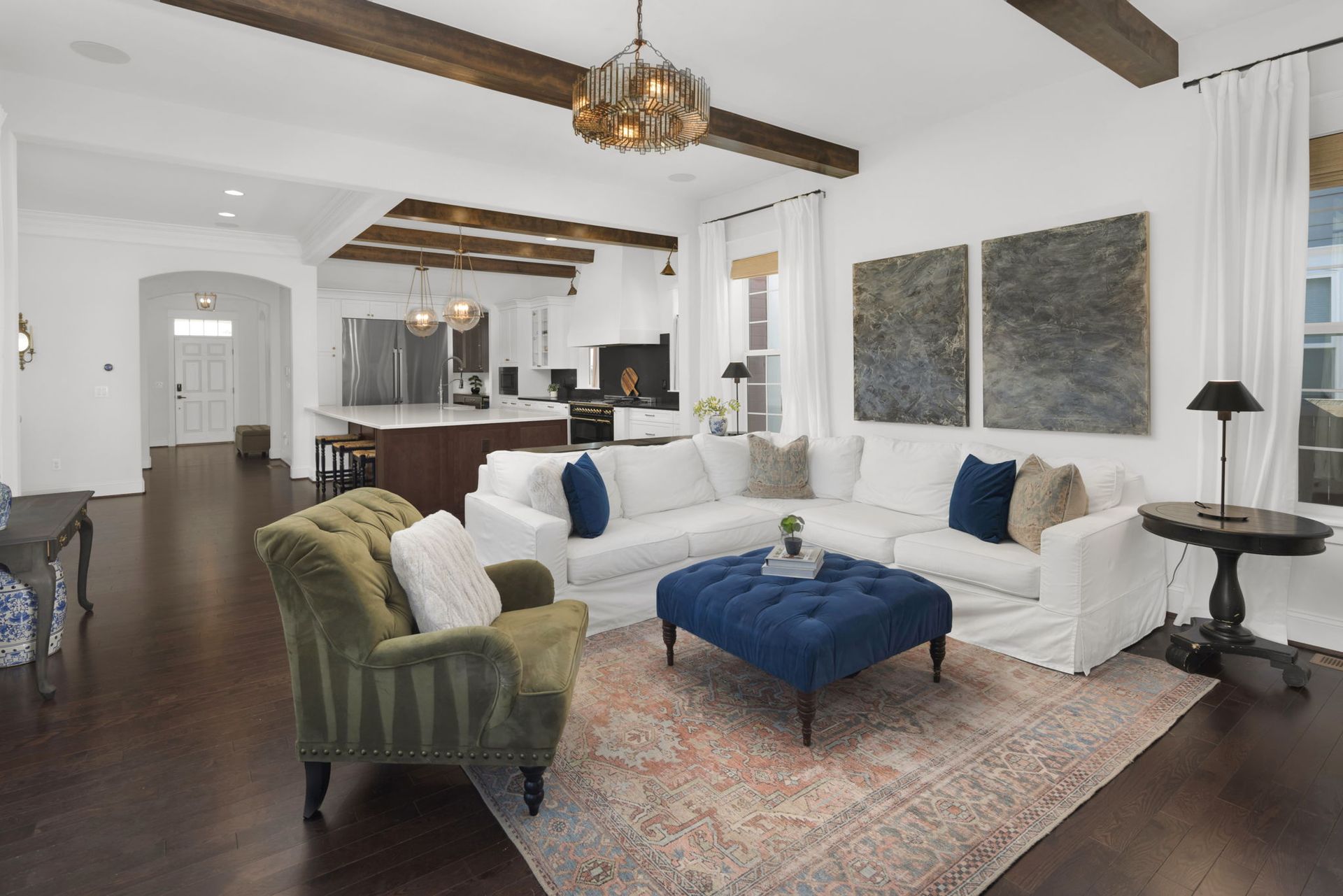 A living room with white furniture and a blue ottoman