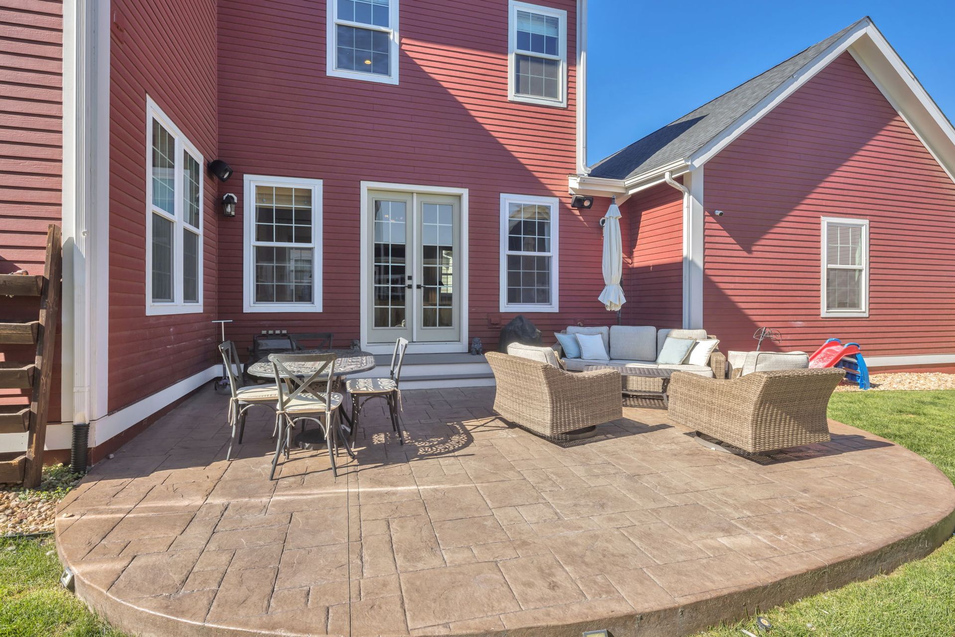 A large red house with a patio in front of it