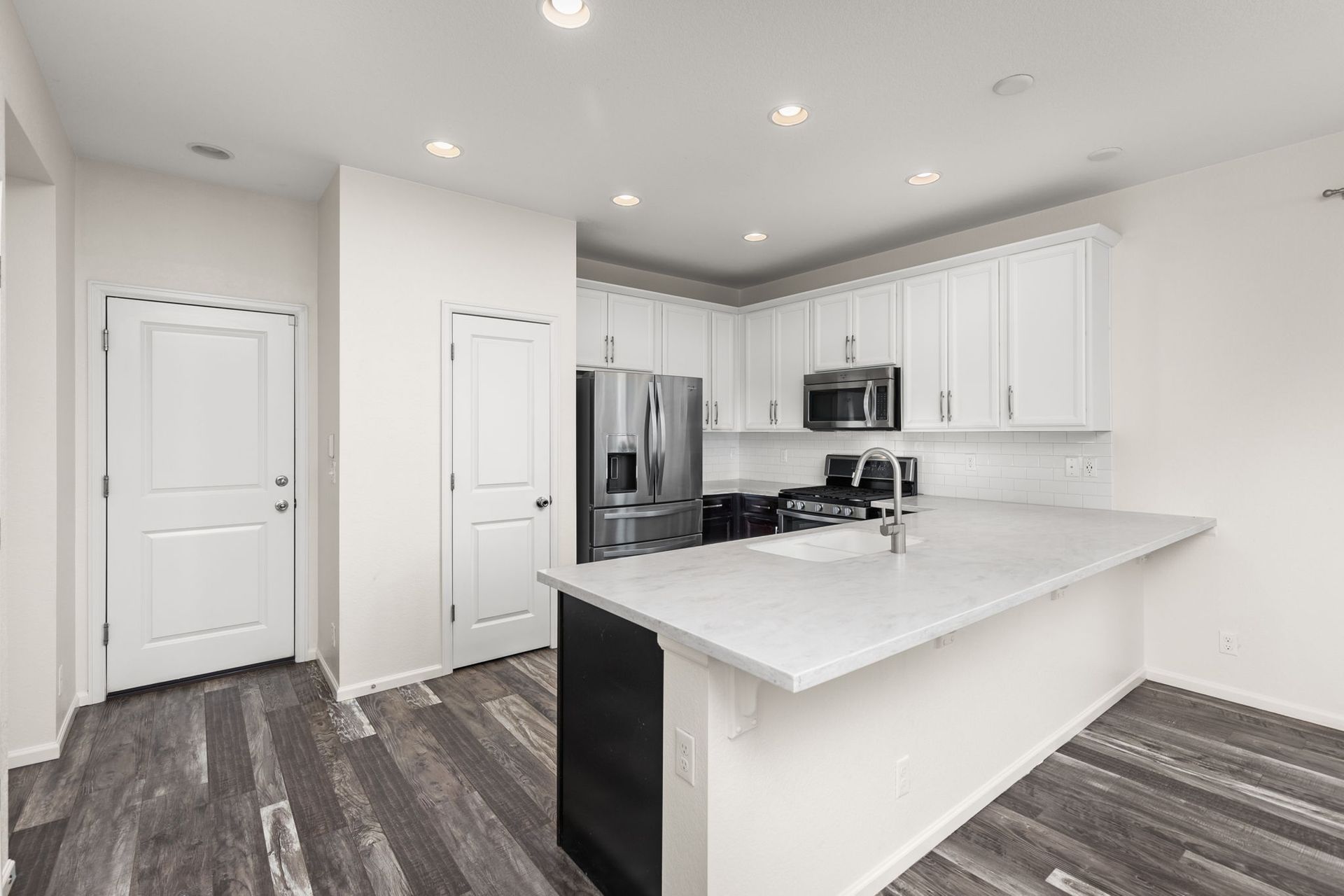 A living room with a dining table and chairs and a sliding glass door.