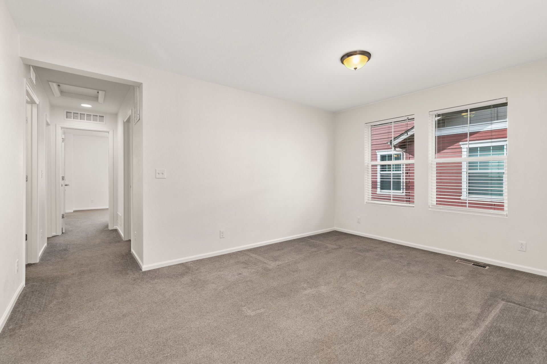 An empty living room with a fireplace and sliding glass doors.