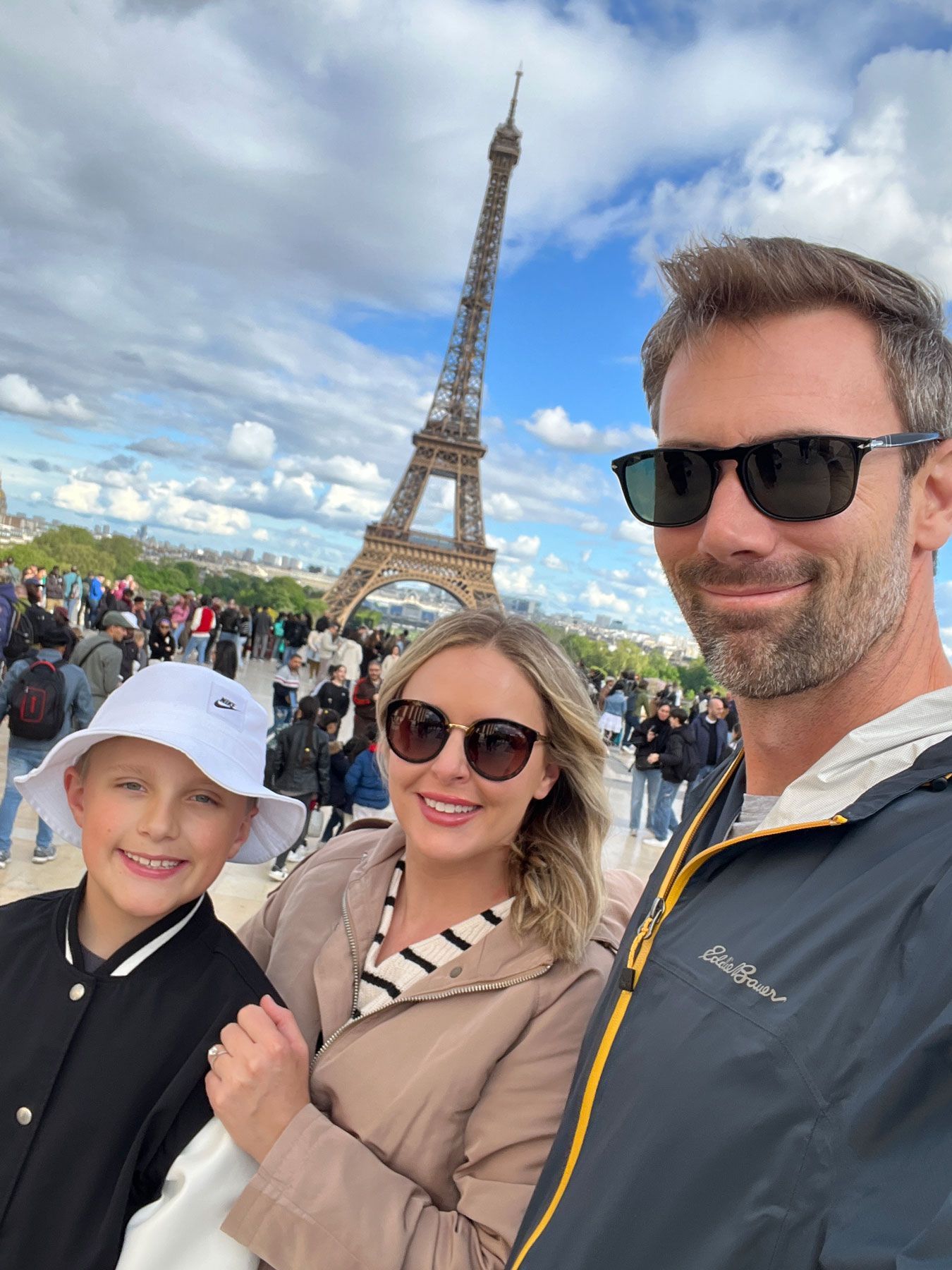 A group of people are standing on top of a mountain with their arms in the air.