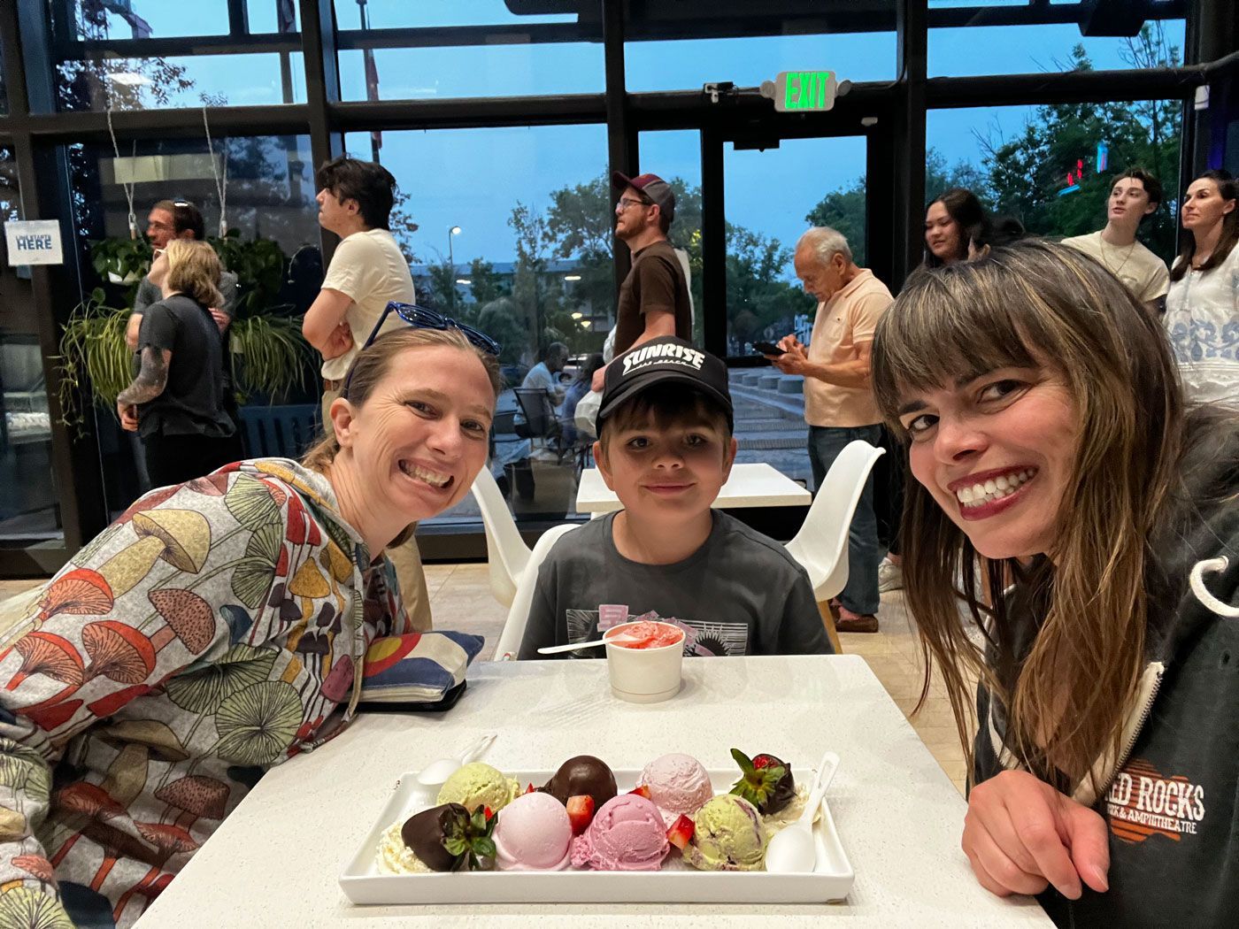 A group of people are sitting at a table with a tray of food.