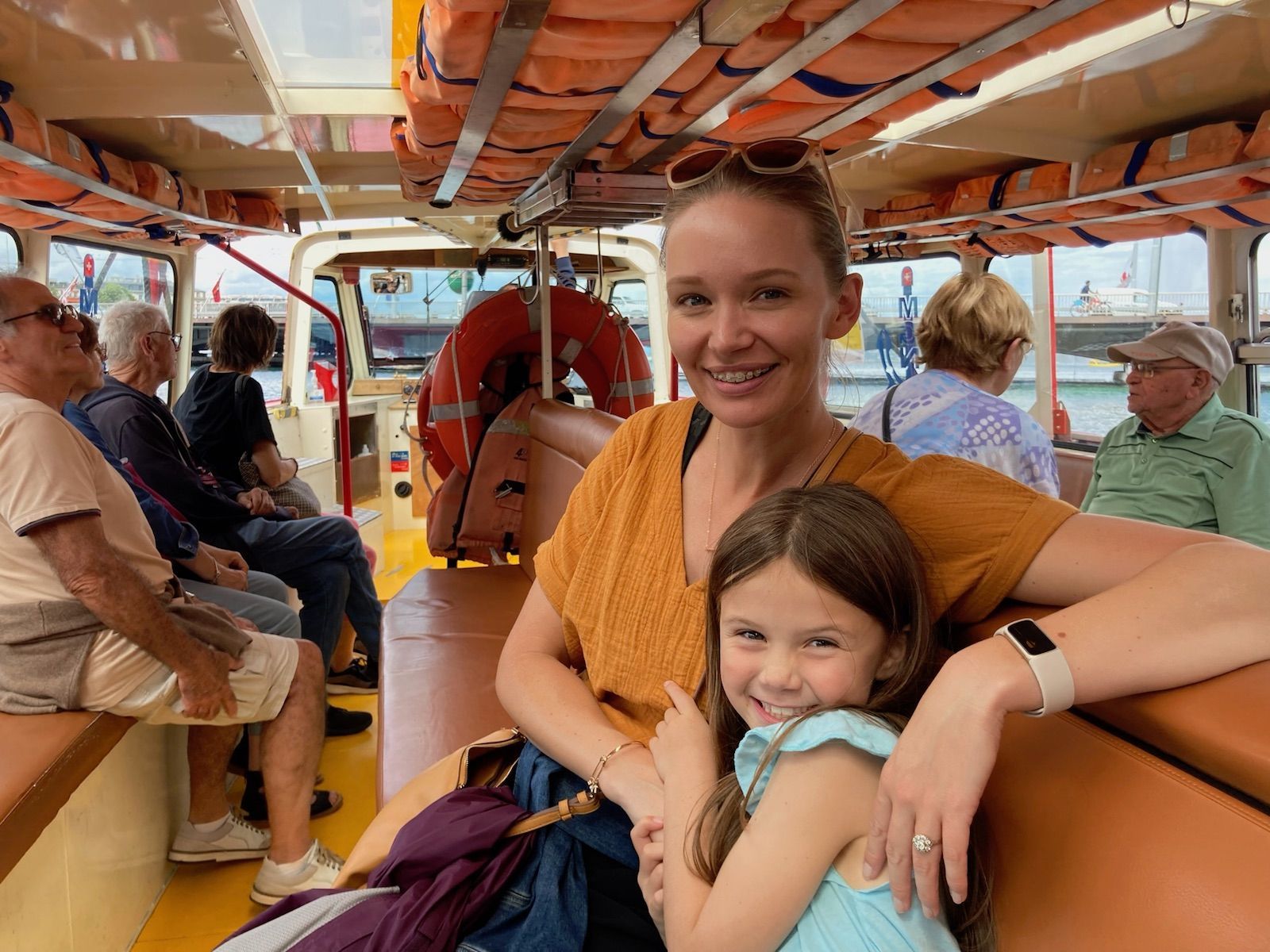 A woman and a little girl are sitting on a boat.