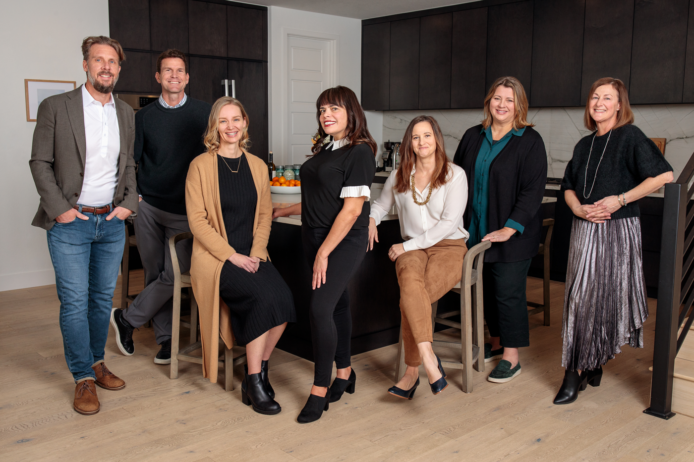 A group of people are posing for a picture in a kitchen.