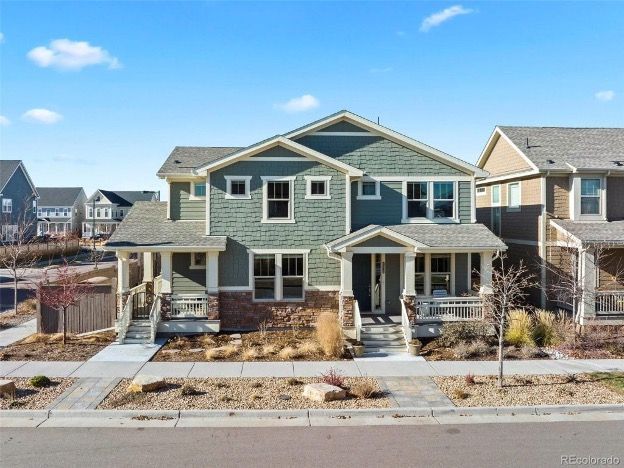 A large house with a lot of windows and a porch in a residential area.