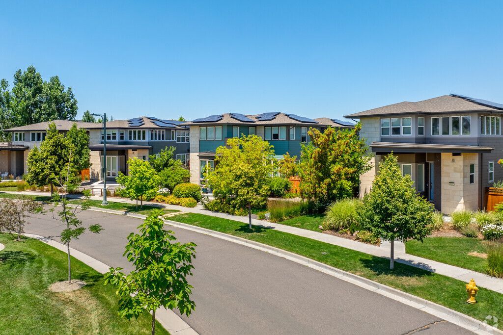 A row of houses are lined up on a sunny day in a Central Park Colorado residential neighborhood.