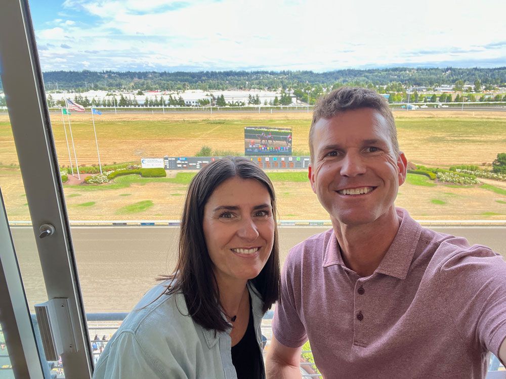 A man and a woman are taking a selfie in front of a window.