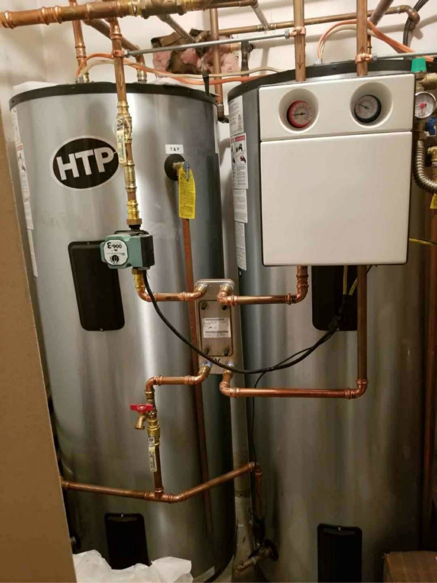 Two htp water heaters are sitting next to each other in a room.
