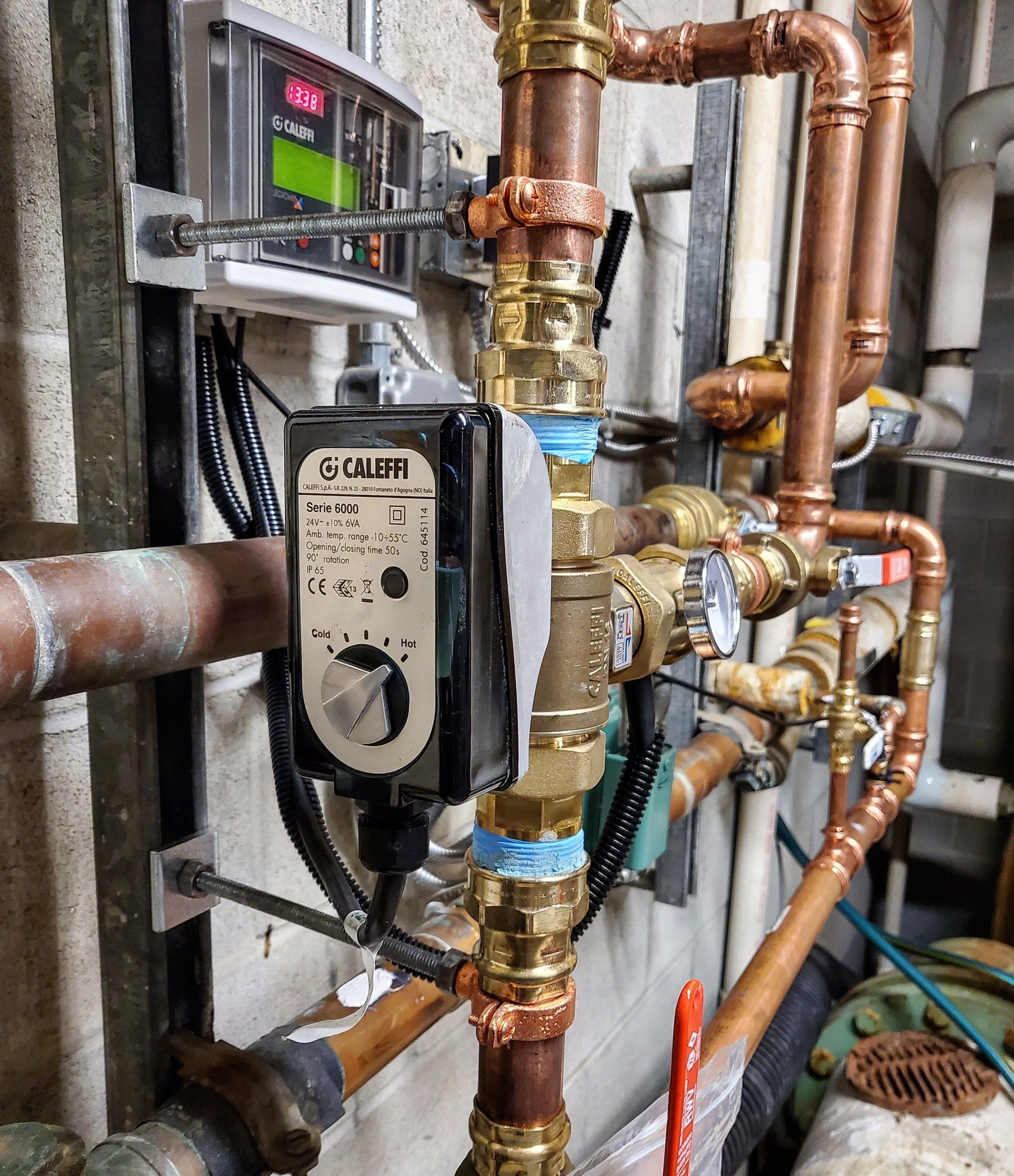 A close up of a copper pipe with a controller on it