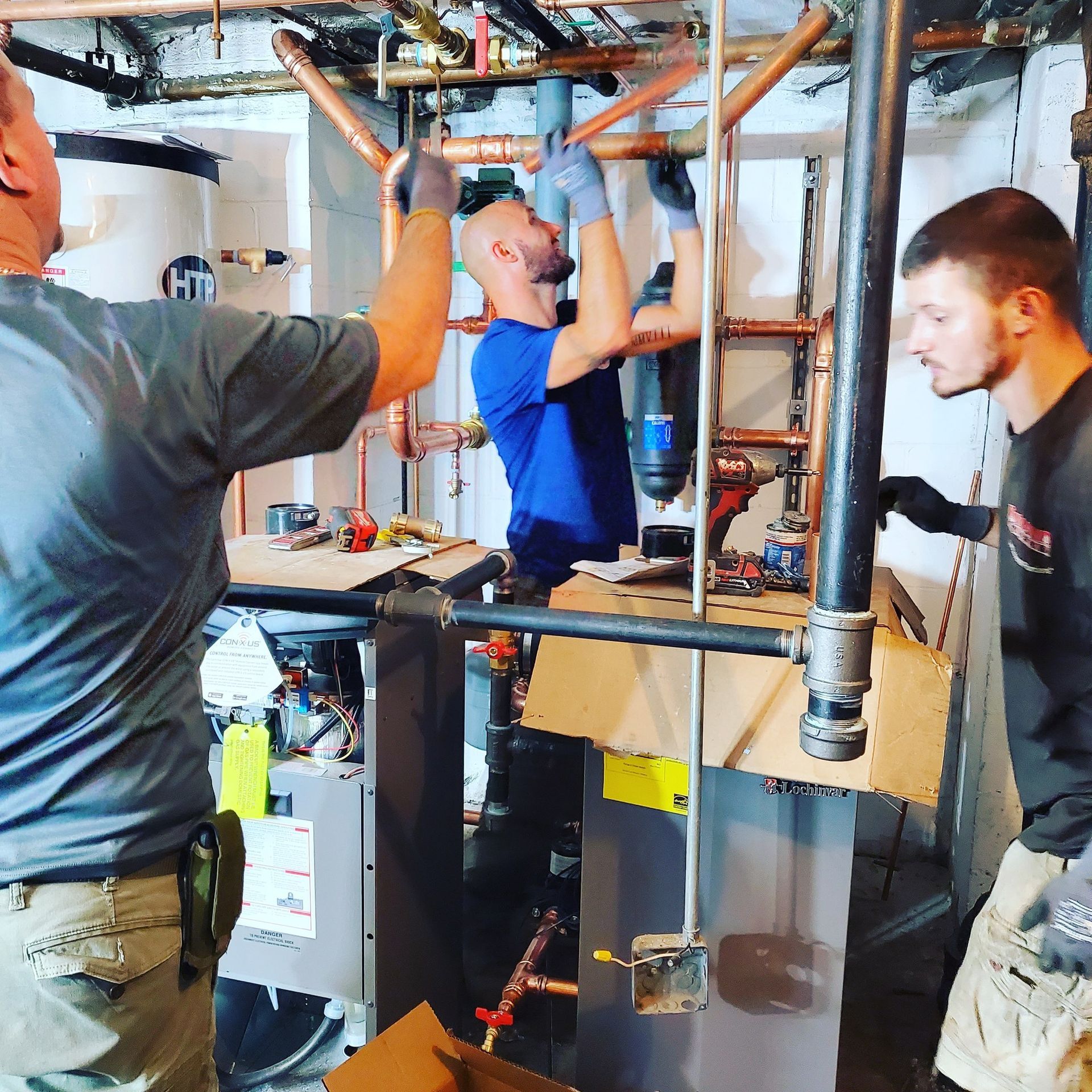 A group of men are working on a heating system